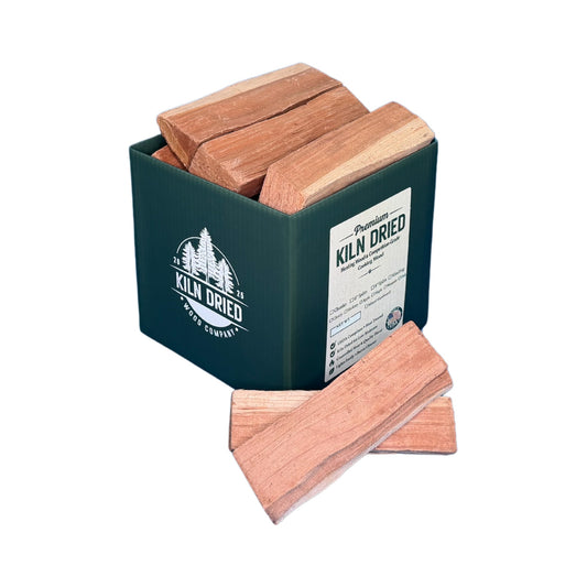 8-inch kiln-dried cherry cooking wood splits in branded Kiln Dried Wood Company box with loose cherry pieces on white background for smokers, grills, and wood-fired cooking